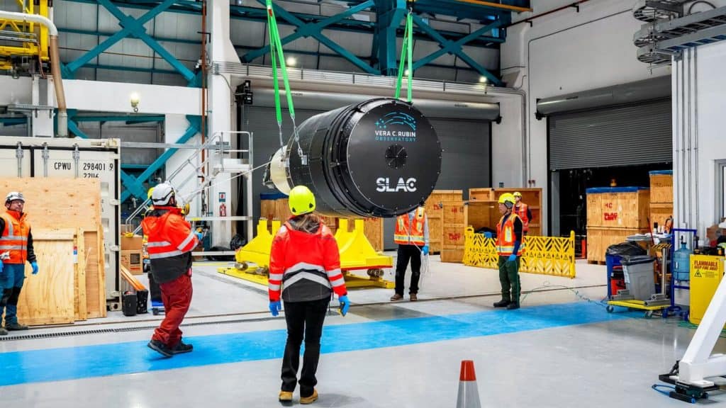 Funcionários olhando câmera LSST, a maior câmera digital do mundo, sendo içada no Observatório Vera C. Rubin, no Chile