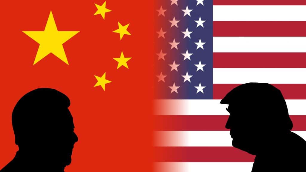 Silhuetas de Xi Jinping e Donald Trump na frente de bandeiras da China e dos Estados Unidos, respectivamente