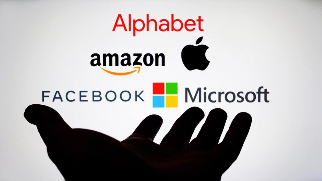 Silhueta de mão na frente de ícones das big techs Alphabet, Amazon, Apple, Facebook e Microsoft