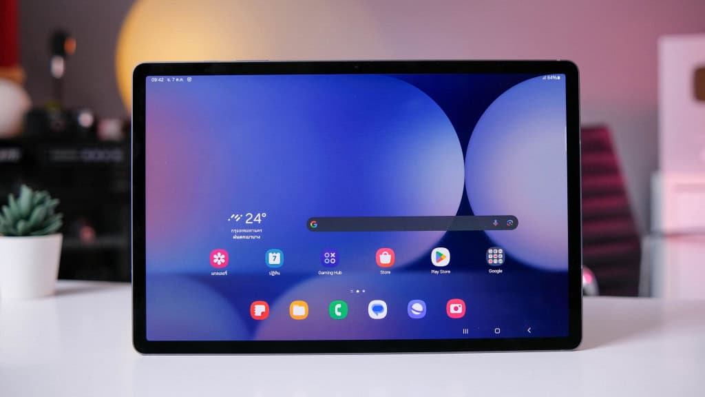 Tablet Galaxy Tab S10 Plus em pé, na horizontal, com tela acesa mostrando tela inicial do One UI em cima de mesa