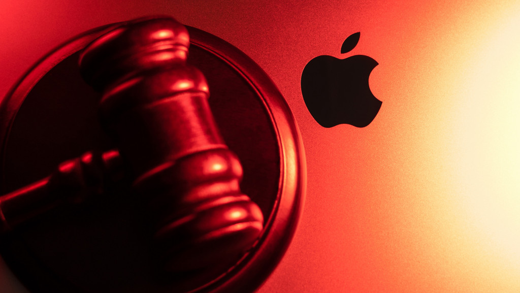 Martelo de juiz em cima de um MacBook, exibindo o logo da Apple ao lado