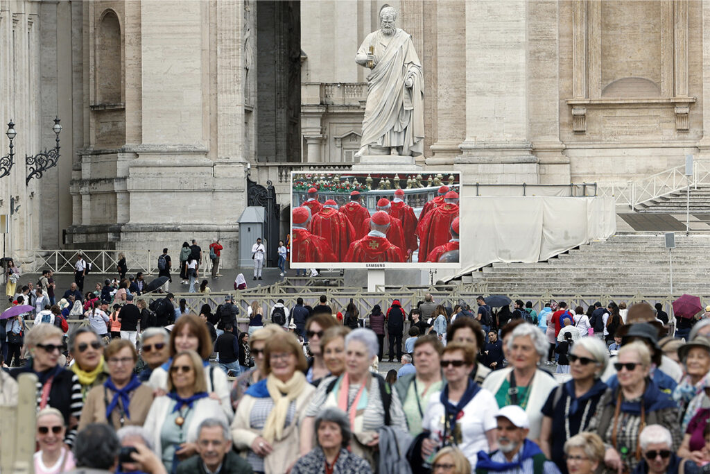 Emocionados, fiéis acompanham início do Conclave em telões no Vaticano