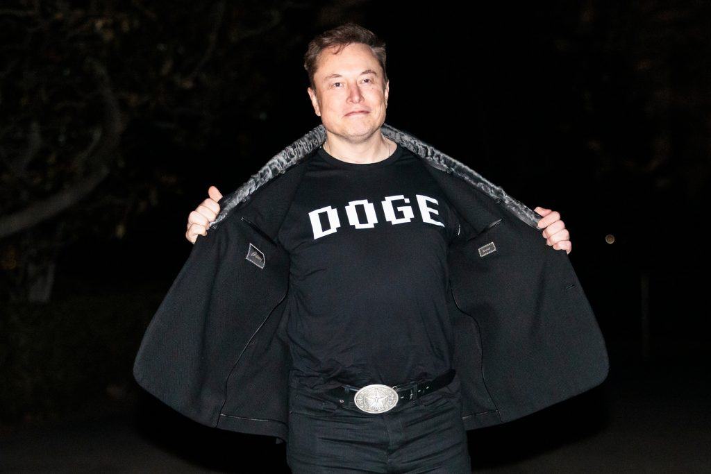 Elon Musk usando uma camiseta com os dizeres 