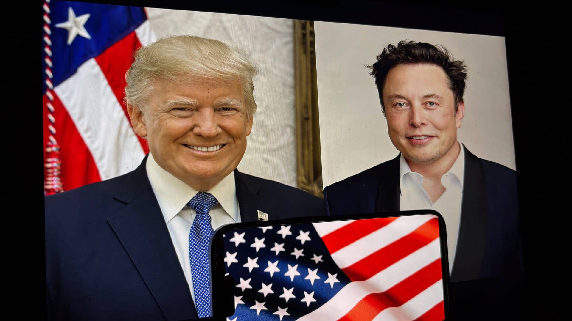 Ao fundo, fotos de ELon Musk (direita) e Donald Trump (esquerda); à frente, parte da bandeira dos EUA tremulando na tela de um smartphone