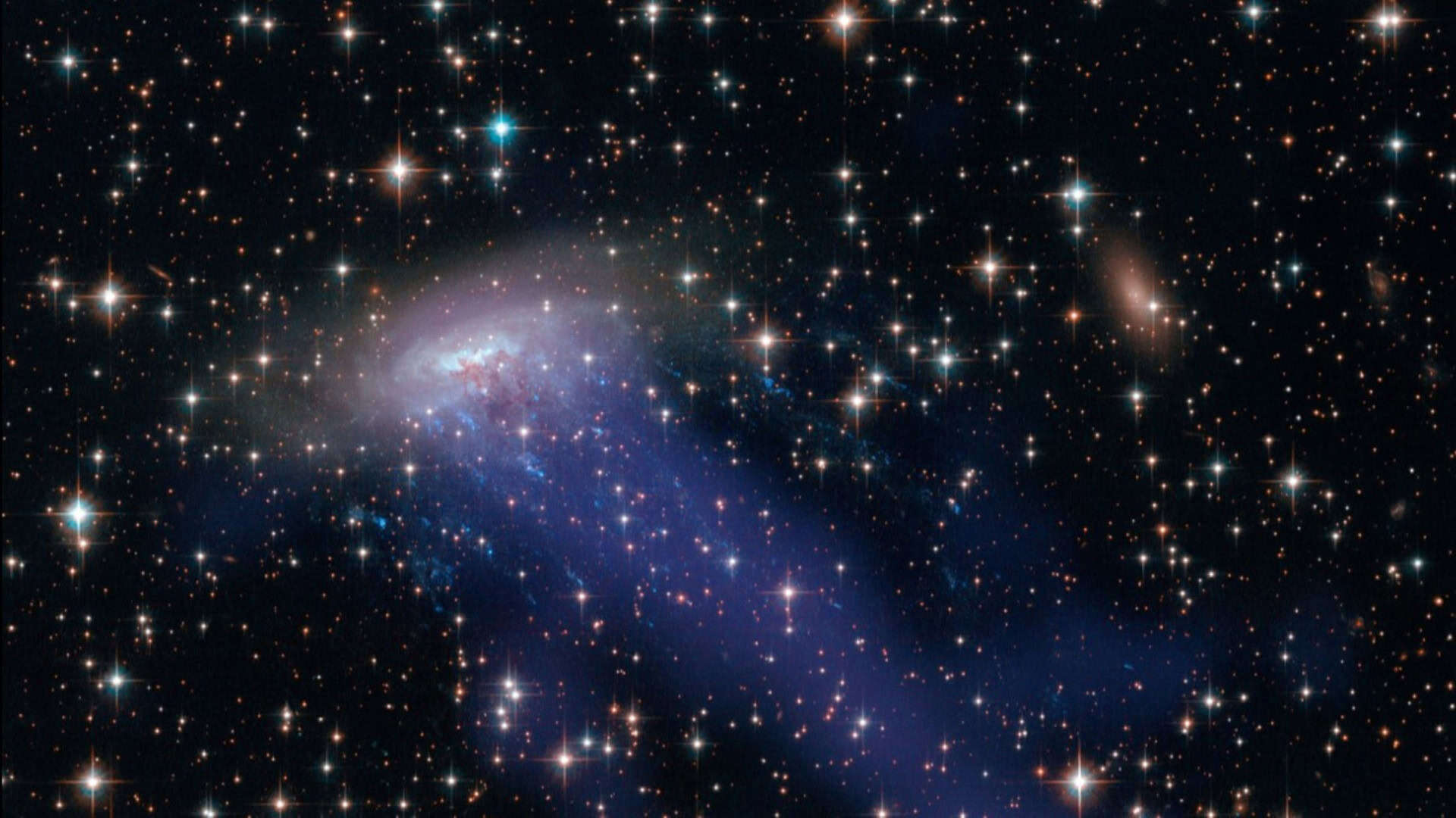 Esta imagem composta do ESO 137-001 inclui luz visível do Hubble e raios X do Observatório de Raios X Chandra (em azul). Ela revela uma cauda de gás quente que foi arrancada da galáxia.