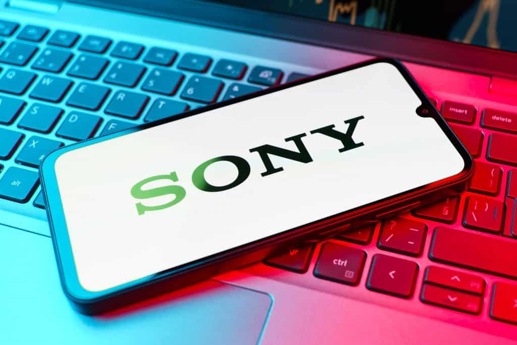 Logo da Sony em um smartphone, que está em cima de um notebook