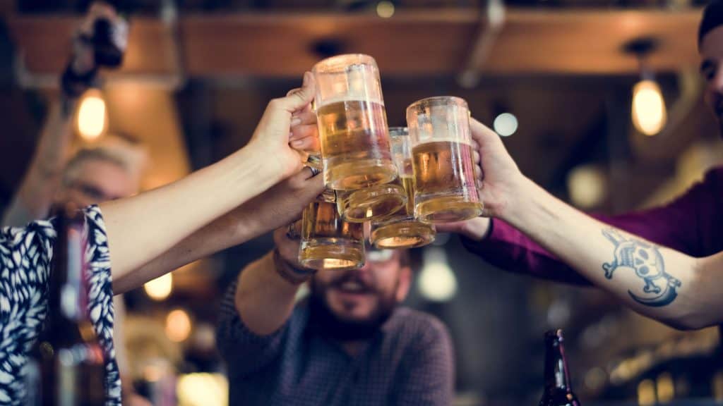 Pessoas brindando com copos de cerveja