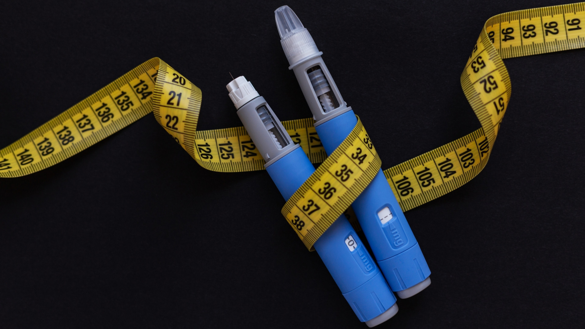 Canetas Ozempic enroladas em fitinha métrica usada para checar perda ou ganho de peso